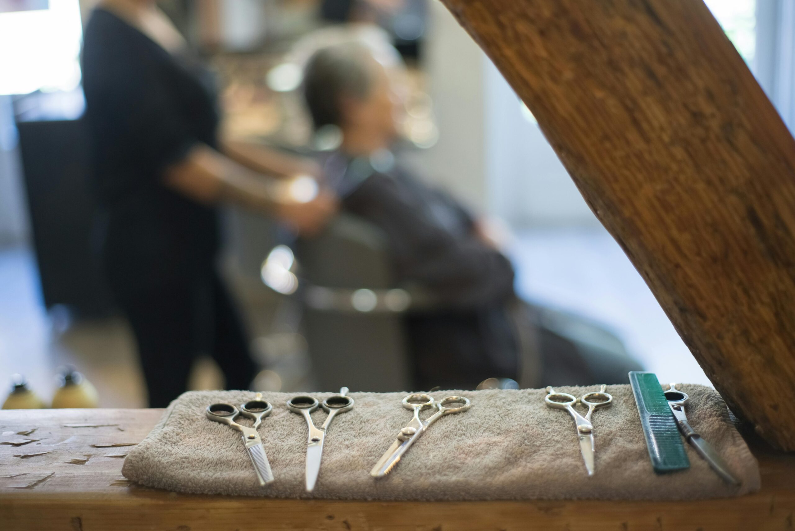 Close-up of barber tools including scissors on a towel in a stylish hair salon setting.
